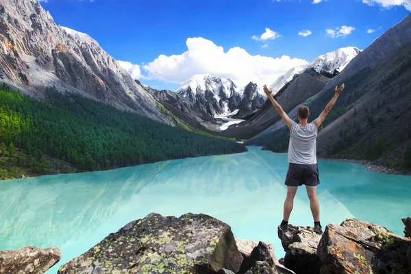 Hiker stående med upphöjda händer nära sjön härligt berg och njuta av utsikt över dalen — Stockfoto