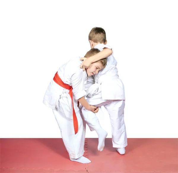 The athlete with the red belt makes capture leg — Stock Photo, Image