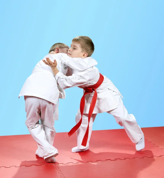 Con una cintura bianca e rossa bambini addestrati tecniche di judo — Foto Stock