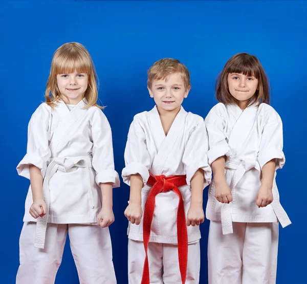 Pojke och två flickor står i rack karate — Stockfoto