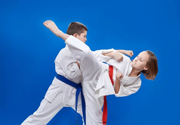 Med rött och blått bälte slår barnen karate slag — Stockfoto