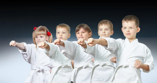 Five little athletes hit a punch on a gradient background — Stock Photo, Image