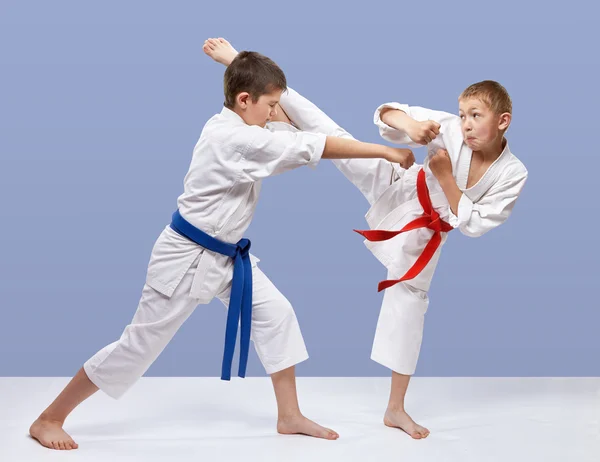 En un fondo gris los atletas están entrenando golpes de karate — Foto de Stock