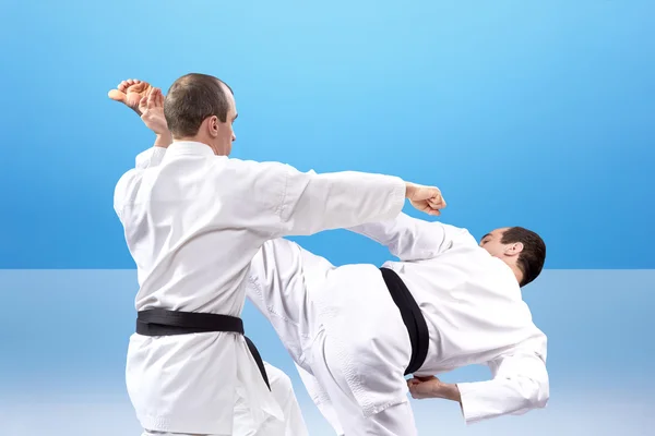 Punch arm and kick leg in the performance of an athlete with black belt  a collage — Stock Photo, Image