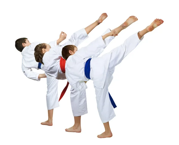 Two boys and a girl in karategi are beating kick leg — Stock Photo, Image