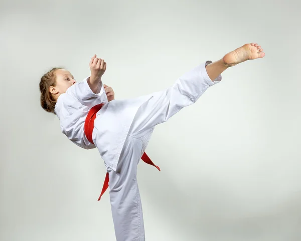 Menina com cinto vermelho golpeia um chute alto — Fotografia de Stock