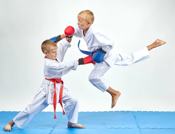 Athlete with a blue belt beats gyaku-tsuki in jump — Stock Photo, Image