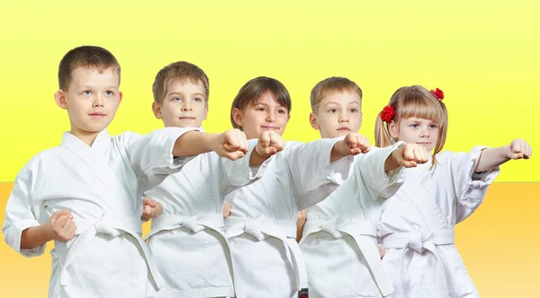 Five little athletes hits a punch arm on a yellow background — Stock Photo, Image