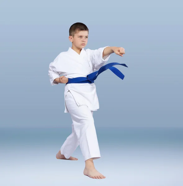 Con un cinturón azul atleta de karate golpea el brazo del golpe — Foto de Stock