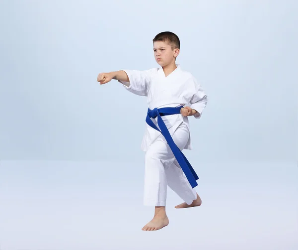 Su uno sfondo leggero karate ragazzo batte pugno braccio — Foto Stock
