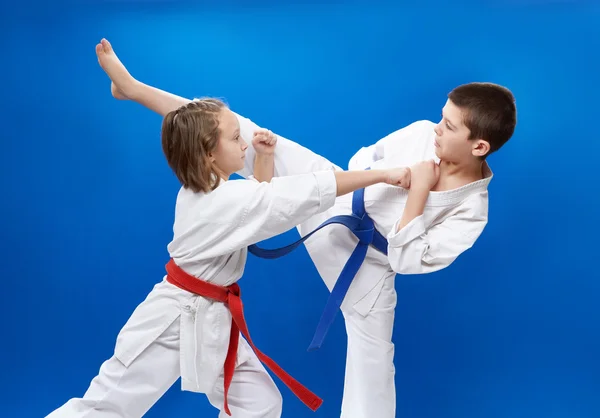 I kararedräkt två idrottare gör blockerar och sparkar av karate — Stockfoto