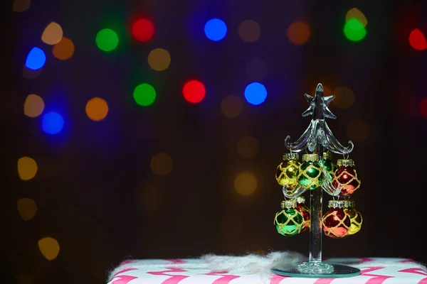 Christmas tree and gift on the background of multi-colored lights