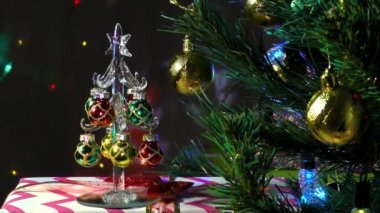 Küçük bir Noel ağacı süslenmiş bir Noel ağacının yanında duruyor.