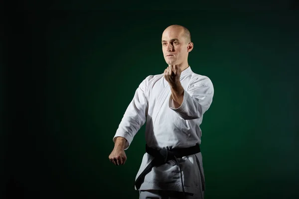 Atleta Activo Realiza Ejercicios Formales Karate Sobre Fondo Verde Oscuro —  Fotos de Stock