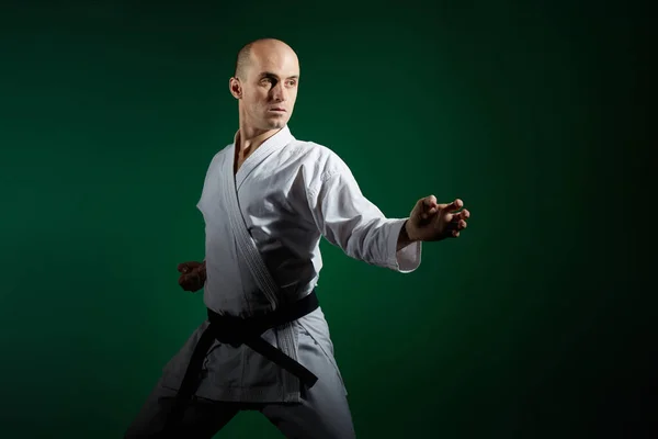 Auf Dunkelgrünem Hintergrund Führt Ein Aktiver Sportler Formale Karate Übungen — Stockfoto