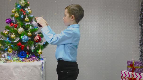Хлопчик Блакитній Сорочці Прикрашає Ялинку Новорічними Іграшками — стокове відео