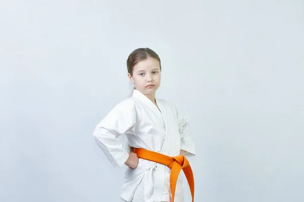 Sportswoman with an orange belt on a light background