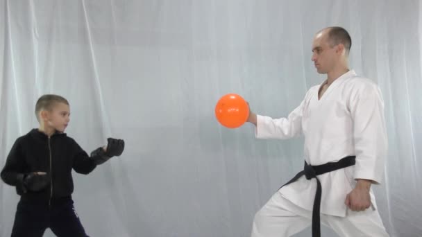 Ein Junge Mit Trainingsanzug Schlägt Den Orangefarbenen Ball — Stockvideo