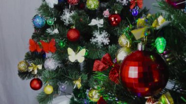 Noel oyuncakları ışıklandırılmış arka plandaki bir Noel ağacına yakın plan çekilmiş.