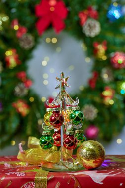 Noel ağacı arka planında kısmen bulanık bir Noel balosu ve küçük bir Noel ağacı