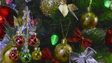 Kırmızı arka planda küçük bir Noel ağacı büyük bir Noel ağacının yanında duruyor.