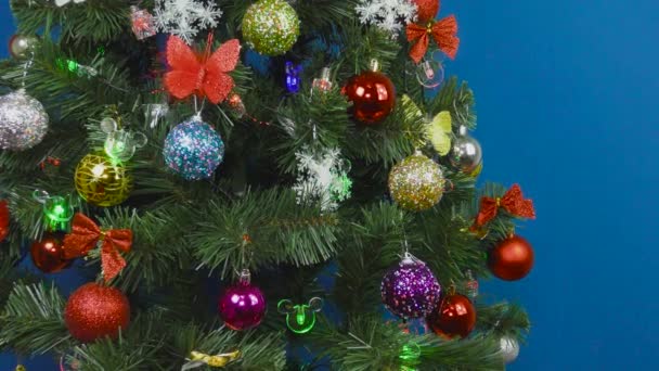 Vánoční stromeček zdobené různými hračkami na modrém pozadí