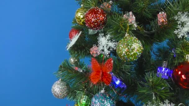 Ein Weihnachtsbaum Dreht Sich Auf Blauem Hintergrund Geschmückt Mit Einem — Stockvideo