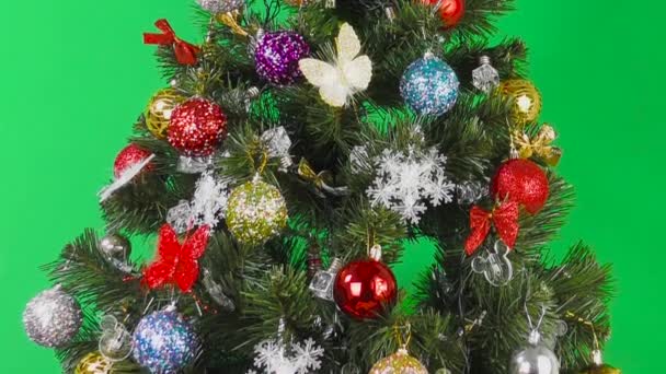 緑の背景にカラフルなおもちゃで飾られた大きな美しいクリスマスツリー — ストック動画