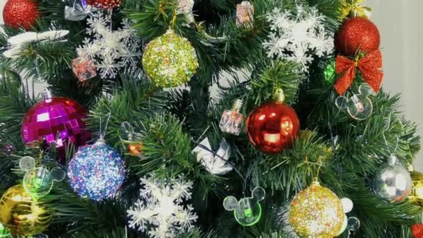 Blinkende Glühbirnen Und Bunte Dekorationen Auf Einem Weihnachtsbaum Vor Hellem — Stockvideo