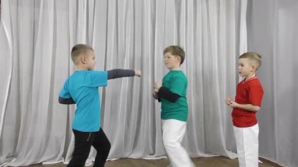 三个身穿五颜六色T恤衫的男孩运动员在做双人运动 — 图库视频影像