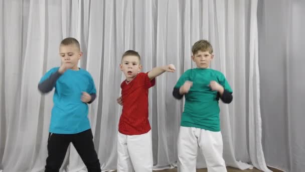 三个身穿五颜六色T恤衫的男孩运动员进行配对练习 — 图库视频影像