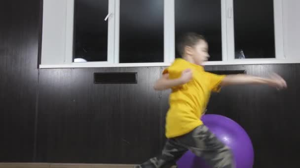 穿着黄色T恤的运动员在球上直拳和圆形踢腿 — 图库视频影像