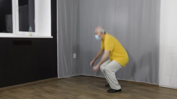 Viejo Atleta Cuclillas Entrenamiento Máscara Médica Con Rebotes Por Ventana — Vídeos de Stock