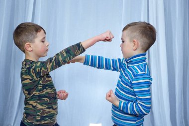 On a light background with a blue tint, two athletes train paired exercises, strikes towards each other