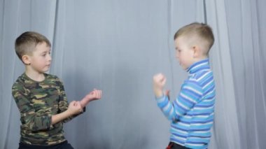 On a light background, two athletes train paired exercises strikes towards each other