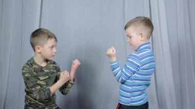 On a light background, two athletes do paired exercises, strikes towards each other