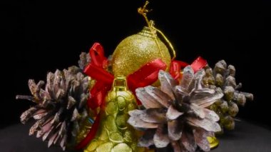 Altın madalyalı Noel balosu Noel ağacı konileri ve çanları ile çevrili