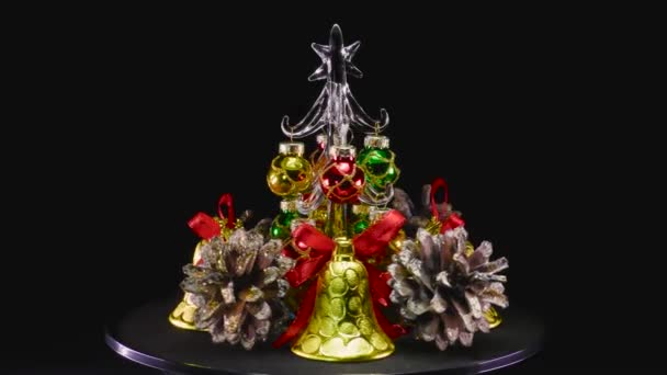 Small Christmas Tree Surrounded Bells Cones Rotates Surface — Stock Video