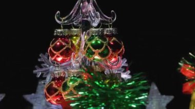 Yeni yıl video kartı. Kar taneleri arasında küçük bir Noel ağacı. Kırmızı ışık alan çanlar ve yıldızlar.