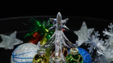 Yeni yıl video kartı. Etrafı kar taneleri ve toplarla çevrili. Yaklaşan küçük bir Noel ağacı.
