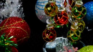 Etrafı kar taneleri ve toplarla çevrili bir video kartpostalı yaklaşan küçük bir Noel ağacı.
