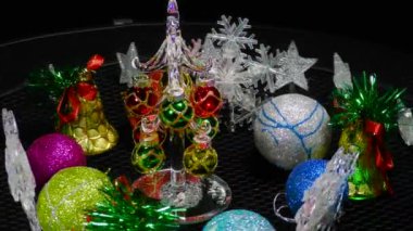 Etrafında kar taneleri, çanlar ve toplar, hareket halindeki küçük bir Noel ağacı