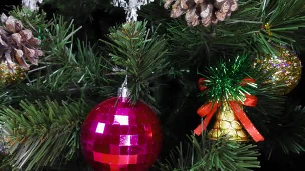 用彩球 球果和铃铛装饰的活动中的绿色圣诞树特写 — 图库视频影像