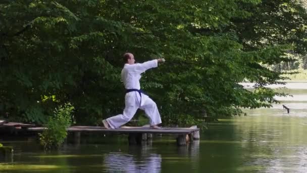 Een Man Atleet Voert Stoten Trappen Brug Tegen Achtergrond Van — Stockvideo