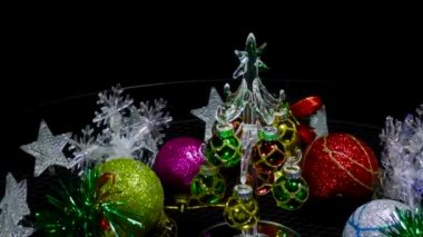 Yeni yıl video kartı hareket halinde. Etrafı kar taneleri ve balolarla çevrili. Küçük bir Noel ağacı.