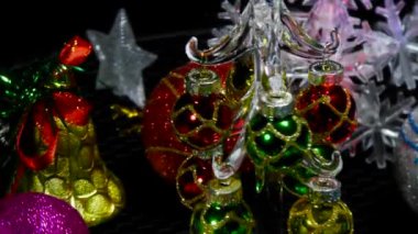 Yılbaşı kartı hareket halinde. Etrafı kar taneleri ve balolarla çevrili. Küçük bir Noel ağacı.
