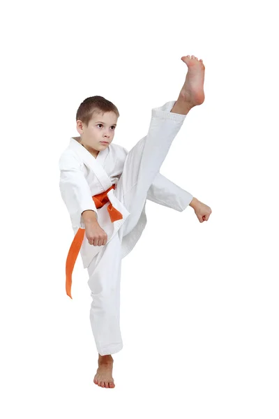 Удар ноги спортсмен выступает с оранжевым поясом — стоковое фото