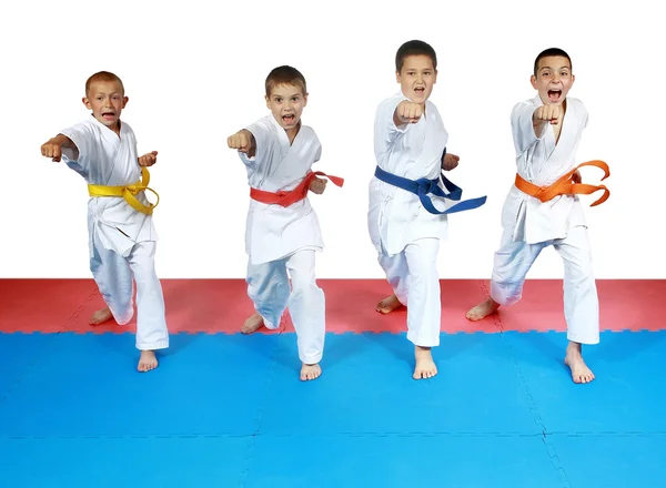 Quatre sportifs en karategi et avec des ceintures battent mains coups — Photo