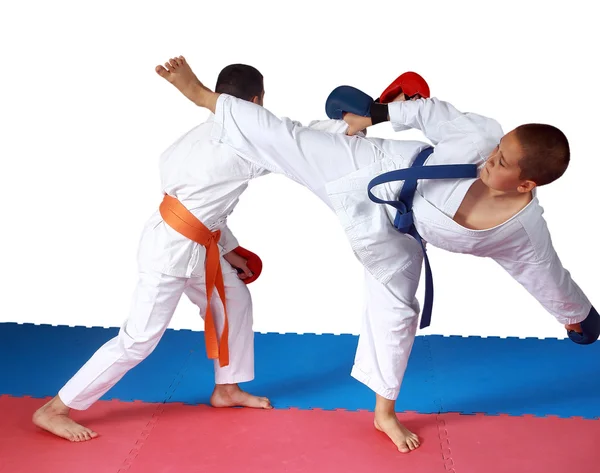 Soplar ura-mawashi geri contra el brazo del ponche en el deportista de perfeccionamiento en karategi — Foto de Stock