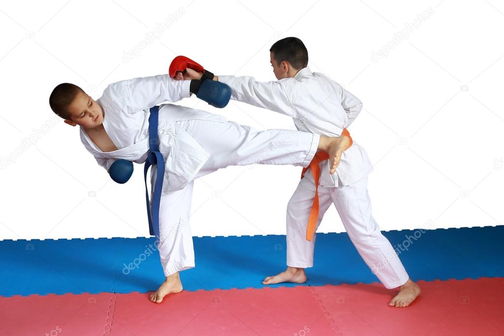 Two athletes in karategi are beating karate blows